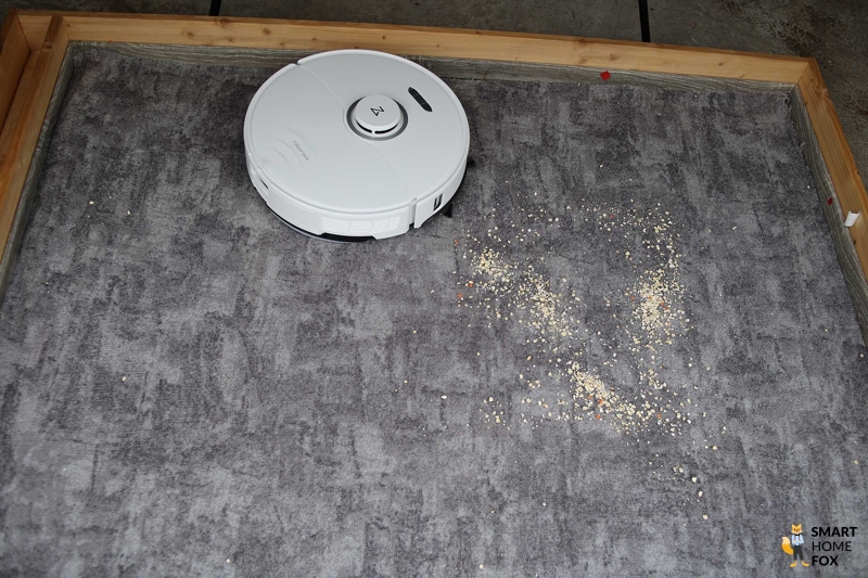 Roborock S8 Pro Ultra убирает овсянку на ковре во время теста на всасывание.